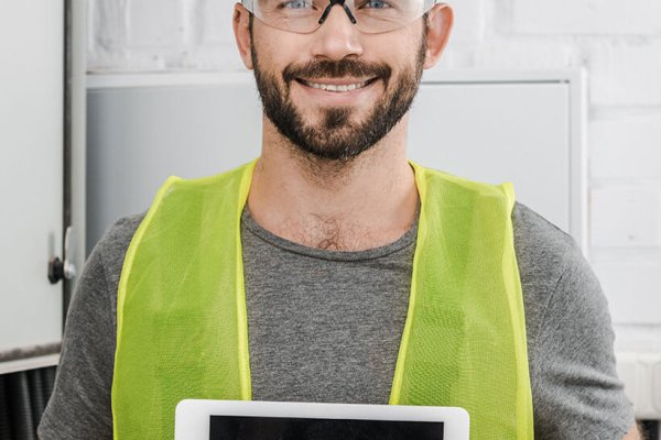 smiling handsome electrician showing tablet